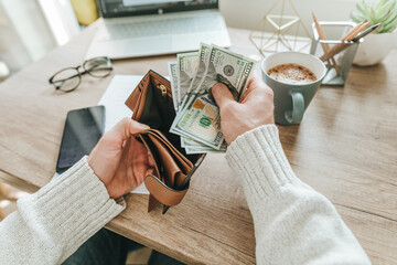 Young man planning budget holding US dollars