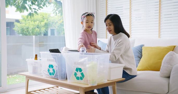Mom teach Gen Z preteen girl kid dump paper glass can e-waste bag in reuse bin recycle bank help climate change social issue in asia people. Trash sorting clean eco green zero waste fun learn at home.