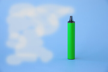 The electronic cigarette vape stands on a blue background and smoke is coming out of it