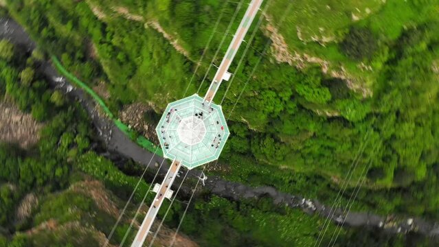 Dashbashi, Georgia - 19th june, 2022: Aerial panning view Diamond shape platform on glass bridge over scenic dashbashi valley in Georgia countryside. Famous modern bridge over valley