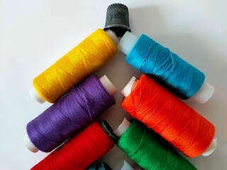 Spools of thread and a thimble on a white background.
