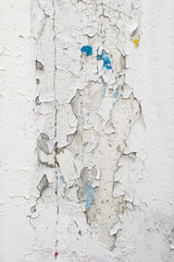 Peeling white paint on damaged wall. 