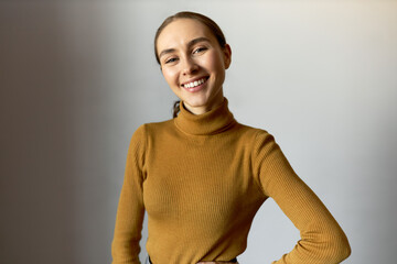 Indoor portrait of young pretty confident self-sufficient happy woman posing against white studio...