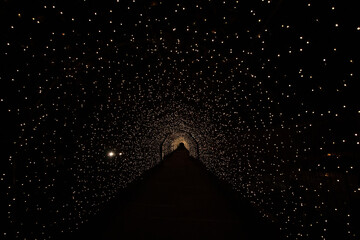 Light Tunnel (Arch Shape) with a fully black background reminder of Halloween, a passage to hell, or cosmos transport inside a galaxy with stars in the dark night. 
