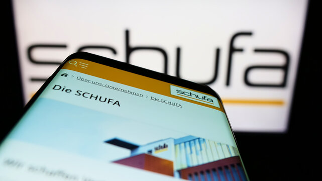 Stuttgart, Germany - 02-13-2022: Mobile phone with website of German credit protection company Schufa Holding AG on screen in front of logo. Focus on top-left of phone display.