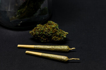 Dried flower marijuana and Pre-Rolls Cannabis Joints on a black background