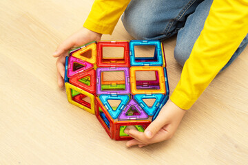Heart made from magnetic building blocks of construction set in child hands.