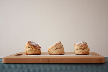  Scones - home made sweet scones on the bread board, side view on the white background 
