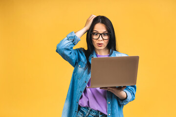 Portrait of happy young beautiful surprised amazed shocked woman with glasses standing with laptop...