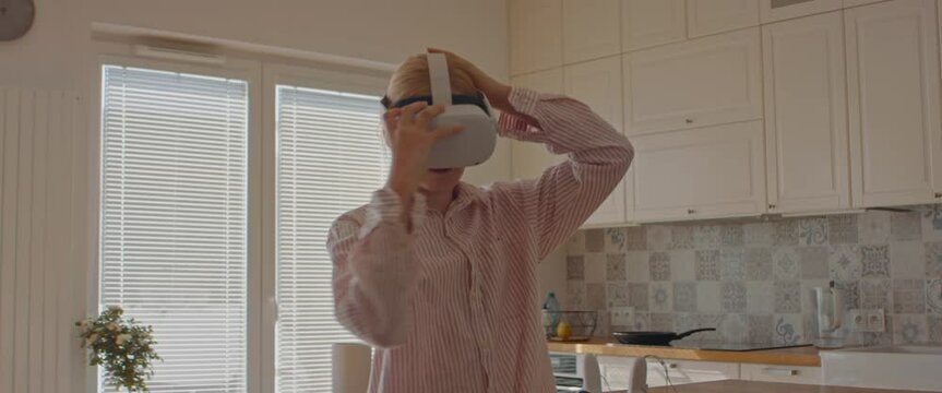 Pre teen girl putting on 360 VR headset at home, starting a virtual reality game. Shot with 2x anamorphic lens