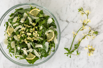 Arugula Salad with Parmesan, Lemon, and Olive Oil, decorated with arugula edible flowers.