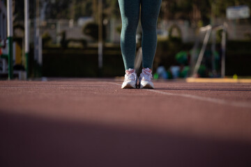 Detalle de pies de mujer en una pista atlética. Concepto de deportes y gente.