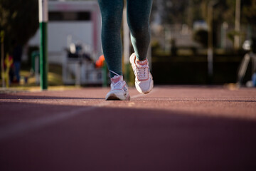 Detalle de pies de mujer corriendo en una pista atlética. Concepto de deportes y gente.