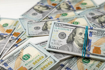 Money, US hundred dollar bills background on white wooden background. Money is scattered on the table. Finance and economics concepts.Money accumulation concept.Currency saving.Investment.Copy space.