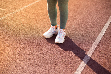close up de pies de deportista en una pista atlética al atardecer. Concepto de personas y estilo...