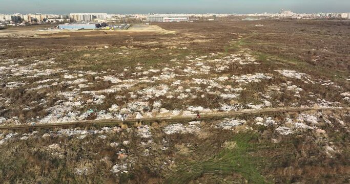 two people walking on a huge aste, garbade, dump, rubbish landill in Bucharest