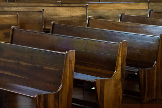 Empty side-by-side wooden pews in a church