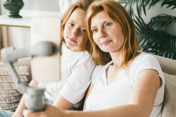 Mom and daughter teenager take a selfie on a smartphone. 