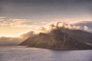 Fototapeten Scenic landscape of mountains along the coast in Hout Bay, Cape Town, South Africa at sunset with cloudy sky and copyspace. Holiday destination for travel and tourism to explore nature and the wild © SteenoWac/peopleimages.com