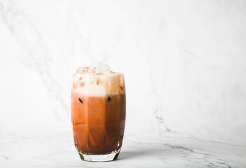 Iced cocoa on top milk in  the cup on marble, copy space for your text