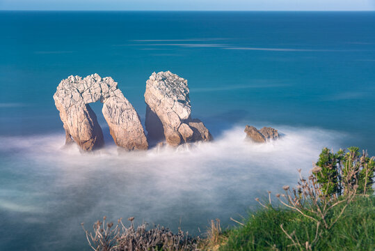 Long exposure view of a beautiful seascape of the spectacular rock formations near the coast in the Cantabrian sea from the cliff edge, Urro in Costa Quebrada, Liencres, Cantabria, Spain