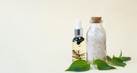 Bottles of sea salt for the bath and body oil, a few green leaves. Banner. - 512852363