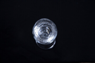 A glass filled with water on a black background