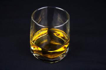 A strong amber whiskey on a black background. Scotch Whisky
