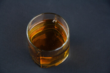 A strong amber whiskey on a black background. Scotch Whisky