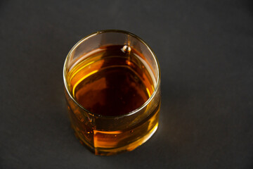 A strong amber whiskey on a black background. Scotch Whisky