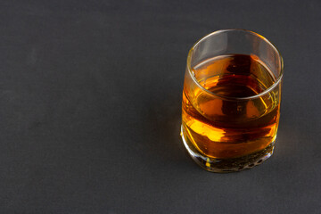 A strong amber whiskey on a black background. Scotch Whisky