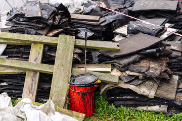 debris left after the repair of the roof. red bucket with mastic