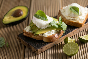 Breakfast concept - toast bread with sliced avocado, pouched egg