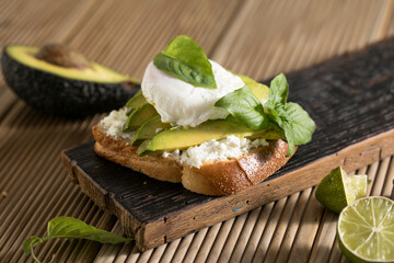 Breakfast concept - toast bread with sliced avocado, pouched egg