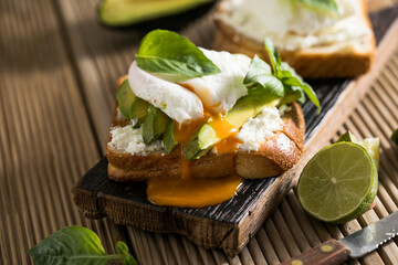 Breakfast concept - toast bread with sliced avocado, pouched egg