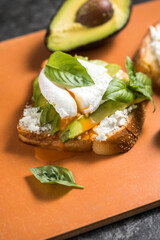 Breakfast concept - toast bread with sliced avocado, pouched egg