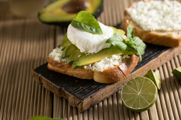 Breakfast concept - toast bread with sliced avocado, pouched egg
