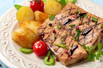 Tofu steaks with vegetables close up.