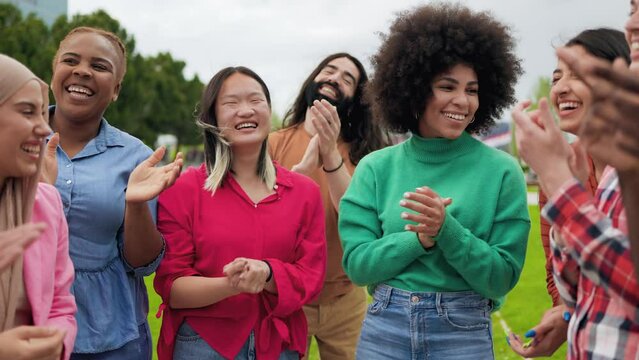 Diverse young friends clapping hands celebrating together outdoor