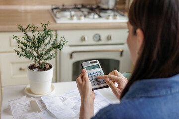 woman pays utility bills and writes checks. a European woman at home makes a calculation of...