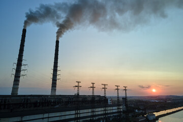 Aerial view of coal power plant high pipes with black smokestack polluting atmosphere. Electricity production with fossil fuel concept