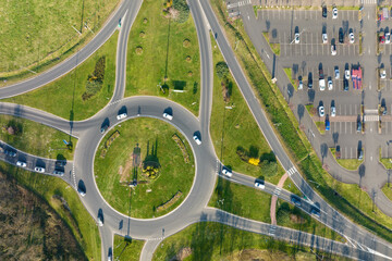 Aerial view of road roundabout intersection with moving heavy traffic. Urban circular...