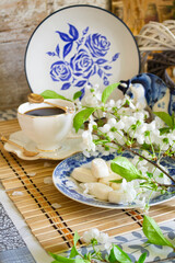 Morning relax, breakfast dishes and decorative elements painted in the style of Gzhel, tea, coffee and white flowers of cherry