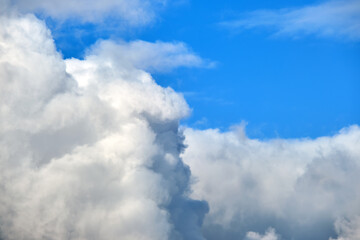 Bright landscape of white puffy cumulus clouds on blue clear sky