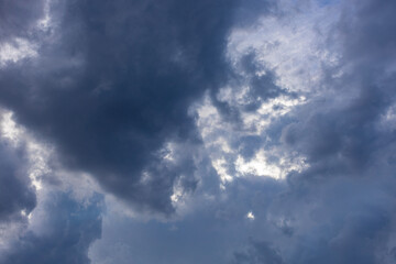 Naklejka na ściany i meble blue skylight with light among dark clouds