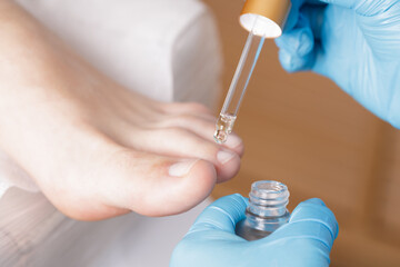 pedicure master applies cosmetic oil for nails with a pipette