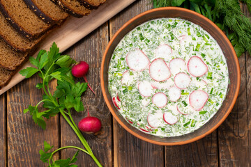 Okroshka, cold soup, summer soup. Okroshka made from radishes, potatoes, eggs, meat and herbs, seasoned with kvass and sour cream. Top view, top view. - obrazy, fototapety, plakaty