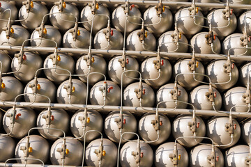 Naklejka na ściany i meble A lot of bottles filled with gas or gasoline are stacked in piles