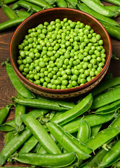 green sweet peas on a dark wooden background, still life, concept of fresh and healthy food