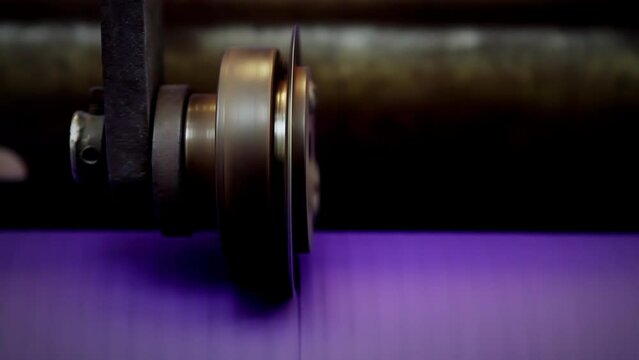 Purple Paper Reel Rolling at a Paper Machine in Pulp and Paper Mill Plant. Close Up. 4K Resolution.